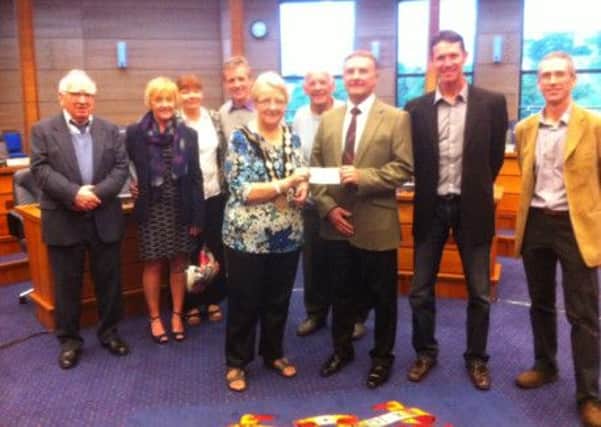 The Mayor Councillor Margaret Tolerton accepts a cheque for her chosen charity from Bill Thompson and members of Alpha Badminton Club who attended a reception to mark the 50th Anniversary of the Christmas Tournament.