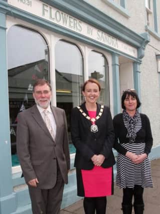 Social Development Minister, Nelson McCausland and Cllr Cara McShane, Chair of Moyle Council meet Sandra McAuley, a local trader, while reviewing improvement works undertaken as part of the recently completed revitalisation scheme in the town. INBM24-14 S