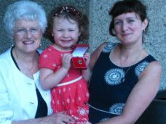 Pat Crossley with her daughter Adrienne, and granddaughter Niamh holding Gold Badge at Barbican Centre London