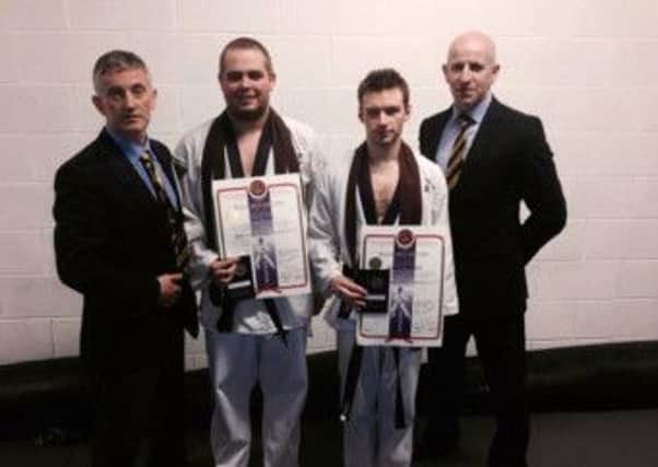 Shihan David Toney with successful students, who also volunteer at the centre, Ryan Avery, Michael 'Mikey' Graham and examiner Master Liam Magill.