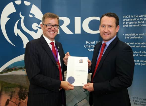Gary McCloskey from Greenisland, a newly qualified member of Royal Institution of Chartered Surveyors, is pictured receiving his diploma from Michael Newey, the global president of the organisation.  INCT24-798-CON