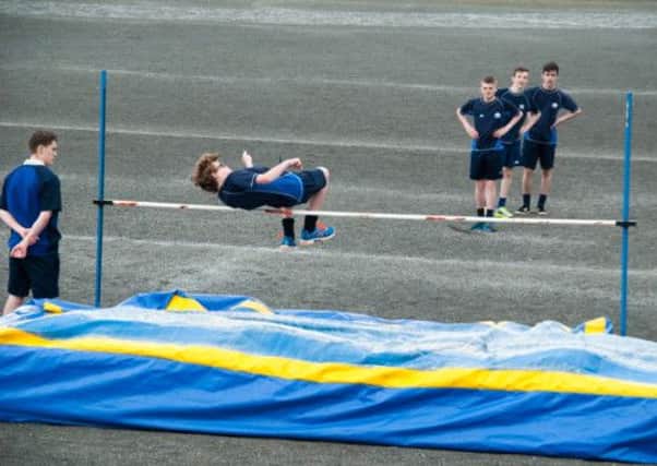 Year 10 pupil Bailey Harrington attempts the high jump as his classmates look on.  INCT 25-731-CON