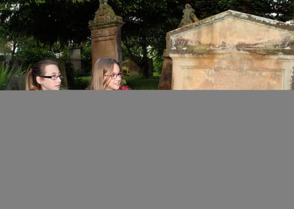 Nicole and Hannah from DH Christie Memorial Primary School gather information from an old grave during the St. Patrick's Church Graveyard Project.
