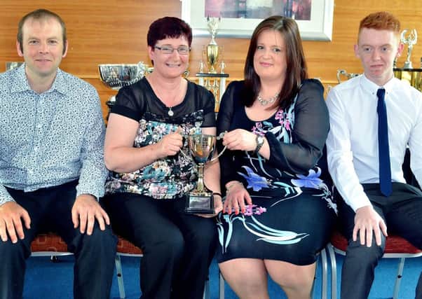 Wakehurst Strollers FC representatives pictured with Mrs Phyllis McIlwee, of league sponsors Michelin Athletic Club, and the Junior Division Three runner-up trophy. INBT 25-844H