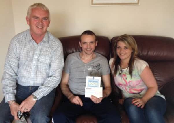 Willis Marshall and Kym Louise Mullholland who presented Michael Pearson with a Recovery Fund cheque for £1,600 recently. Michael was presented with the cheque at his home in Lisburn where he is recovering from his Horice Road Race accident in May.