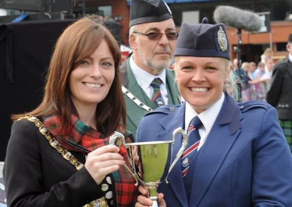 Paula Braiden, Cullybackey Pipe Band, pictured receiving the Adult Grade Drum Major trophy from the Lord Mayor of Belfast, Councillor Nichola Mallon, Chieftain of the Gathering.