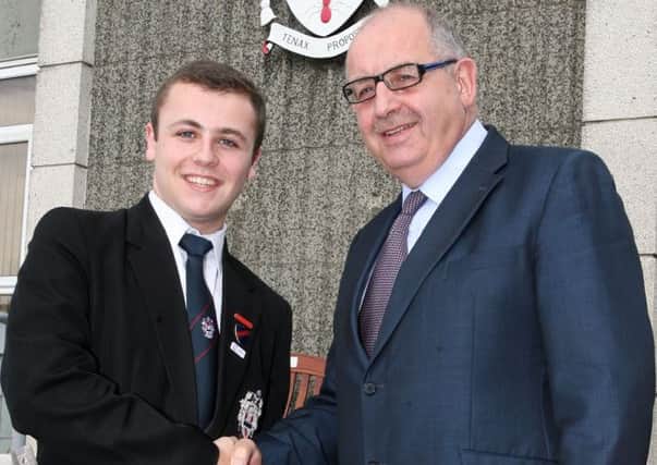 Mr. Ronnie Hassard, principal of Ballymena Academy, congratulates upper sixth student Jason Nicoletti on receiving the Princess Diana award for voluntary work. INBT25-206AC