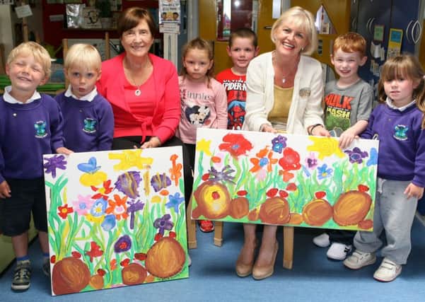 Mrs. Betty Rainey and Mrs. Una Crossey, who retired from the Board of Governors at Dunclug Nursery School, are pictured receiving gifts from some of the pupils. INBT26-202AC