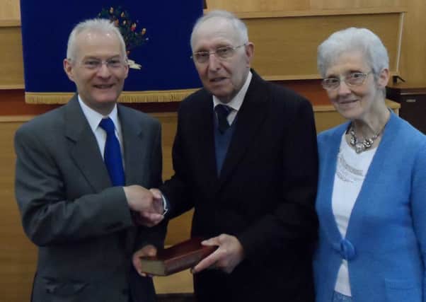 Mr. John McWhirter, centre, recently received an inscribed Bible from Ballee Presbyterian Church to mark the 25th anniversary of his Ordination
and Installation as an Elder in the Congregation. Making the presentation is  The Rev. Joseph Andrews and included is Mrs. Sadie McWhirter INBT 26 CHURCHES STANDALONE MCWHIRTER PRESENTATION.