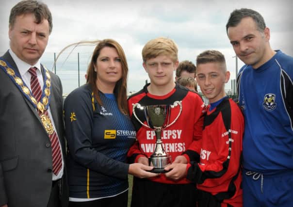 The late Jordan Scott's mum Samantha presents the memorial cup to joint winning captains Josh McAdoo and Luke McCrea during Saturday's memorial tournament played at the Mid-Ulster Sports Arena. Included in the picture is Wilbert Buchanan Cookstown Council Chairman and Johnny Scott (Jordan's Dad).INMM2614-427