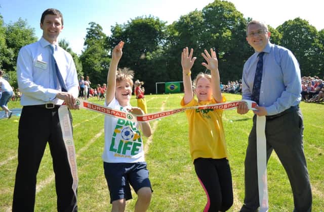 Eurospar Carrick Milestone sponsored Oakfield Primary School sports day. Primary 5 pupils Luke Bennet and Poppy Walker break the tape held by Jonny Mitchell, store manager and George McCluskey, principal (photo: LiamMcArdle.com). INCT 26-797-CON