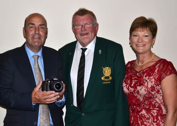 Trevor Doak is presented with the captain's prize by Peter and Norma Cairns.