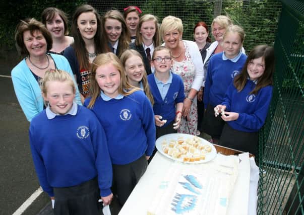Mrs. E. Kirkpatrick, principal of Longstone PS, with pupils past and present at the special cake to mark the schools 110th anniversary. INBT26-204AC