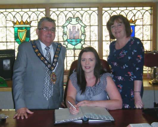 The Mayor of Carrickfergus, Alderman Charles Johnston, invites successful Exploring Enterprise participant Julie Tweedie and Patricia Brennan from LEDCOM to sign the visitors' book at the parlour in the Town Hall. INCT 25-799-CON