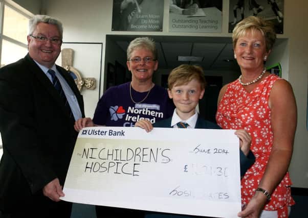 Slemish College pupil Josh Coates who raised £1621.30 for the NI Childrens Hospice by cutting 6 inches of his hair, is pictured presenting a cheque to Heather Montgomery (Ballymena Support Group) and Catherine O'Hara (Hospice). Included is principal Dr. Paul McHugh. INBT27-208AC
