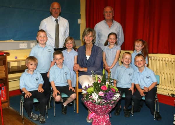Mrs. Valerie Dawson, who retired after almost 23 years teaching at Carnaghts PS, is pictured with her P1 class, husband Freddie and school principal Ian Henderson. INBT27-217AC