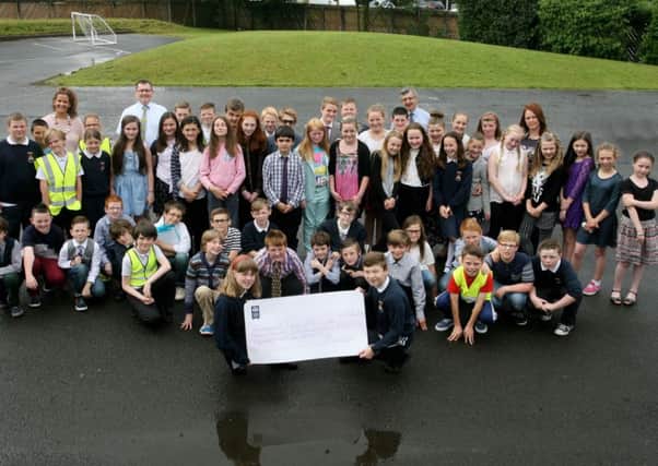 The P7 pupils from Braid Integrated PS with a cheque for £7437.02 that will be presented to the charity Children with Cancer UK. Over £2700 was raised by the parents and staff at a recent "Family Fortunes" night and the rest was raised by a sponsored walk by the pupils. INBT27-218AC