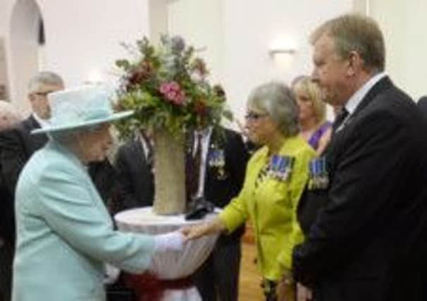 Roberta McNally shakes hands with Her Majesty The Queen.
