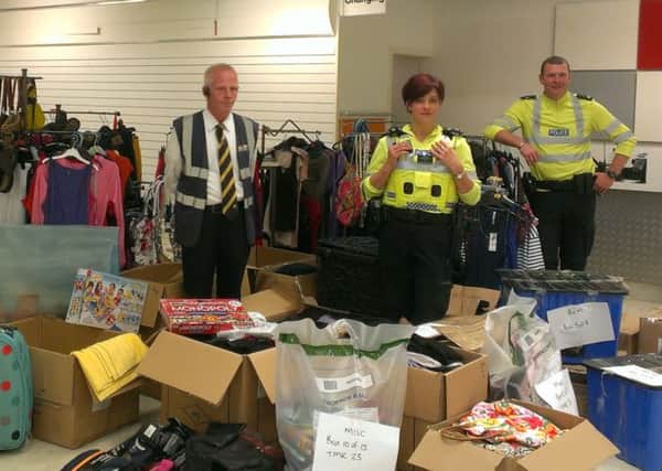 Ballymena PSNI Inspector Alison Ferguson pictured with Town Centre warden Billy Hamilton and Constable Chris Glasgow amidst the £20,000 worth of shoplifted items seized by police which are being returned to shops or donated to local charities.