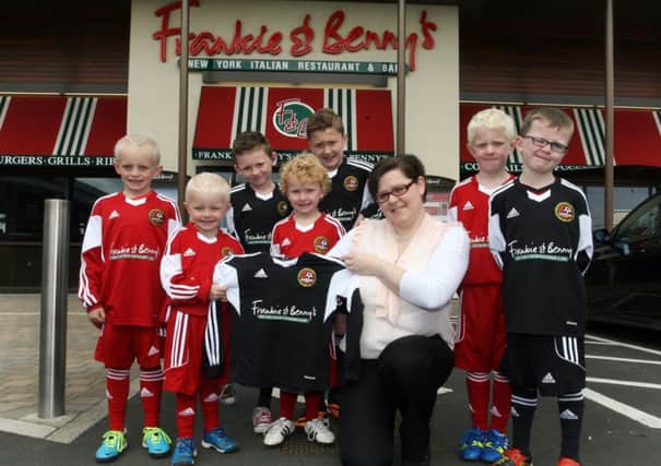 Patricia Robinson, assistant manager of Frankie & Benny's, presenting a new sponsored strip to members of the Carniny Youth Football Development Centre. INBT27-253AC
