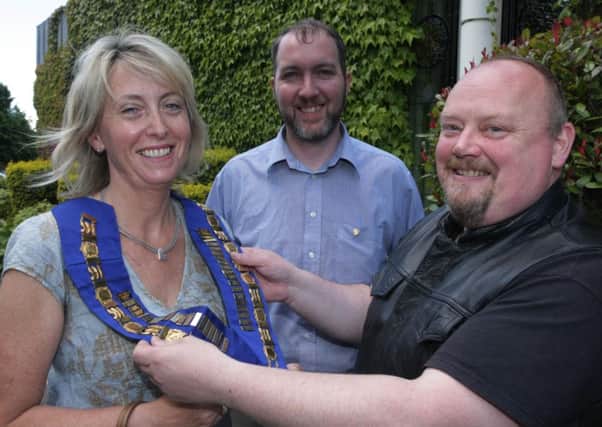 Jeremy Arthur, outgoing President, Londonderry Rotary Club, pictured at the Everglades on Tuesday morning, handing over the chain of office to the new president, and first lady to hold the office, Helen McDonnell. Centre is Peter O'Connor, President Elect. INLS2714MC009