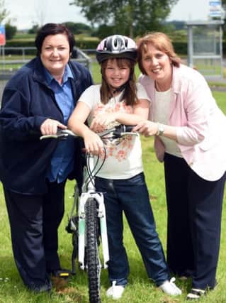 Kacie Turkington is pictured with the mountain bike that she won for her poster in the Council's Dog Warden Service competition as part of the 'Be Safe' initiative. With Kacie are (l-r) Joanne MacAskill, Senior Dog Warden and Councillor Jenny Palmer, Chair of the Council's Environmental Services Committee.