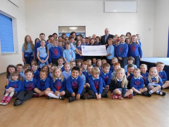 Jimmy Walker, lead Volunteer with the British Heart Foundation, pictured collecting a cheque for £1050 from pupils and staff at Garryduff PS. INBM28-14 S