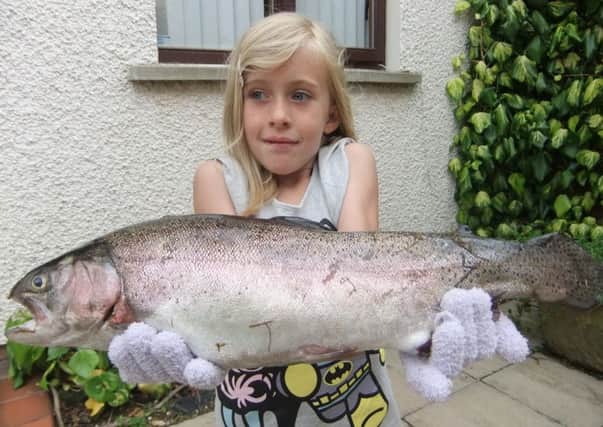 Charley Beatty show off the trout  she caught, weighing just over 3lbs.