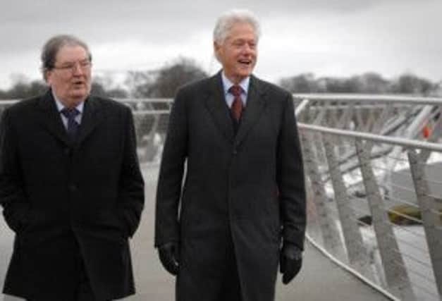 President Bill Clinton walking over the peace bridge with Nobel Laureate John Hume.