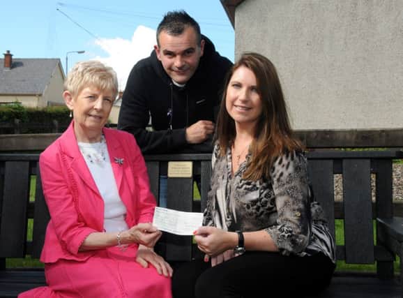Morina Clarke Epilepsy Action Northern Ireland Manager pictured she receives a cheque from the late Jordan Scott's parents Mum Samantha and Dad Jonathan for £7,856.74. The money is after a series of fundraising events held in Jordan's memory from donations in lieu to Watters Funeral Home, Cookstown Youth, a Charity Concert at Cookstown High School and Jordan's Memorial Football Tournament.INMM2914-303