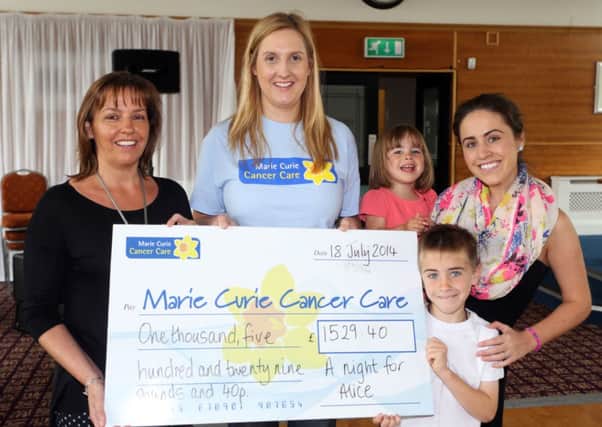 Anne McRoberts of Marie Curie is pictured receiving a cheque for £1529.40 from Paula McAllister with her children Caitlain and Kevin, and mother Jane Scullion. Paula, who is the lead singer of group Mojo, raised the money by organising a charity night in the Michelin Social Club in memory of her grandmother Alice who passed away 25 years ago. INBT30-205AC