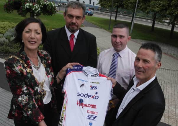 The Mayor of Londonderry, Councillor Brenda Stevensin being presented with a team jersey from Irish cyclist Joe Barr at a civic reception held in his honour. At back are crew members Alan Hamilton and Damien Keys. DER2914MC156