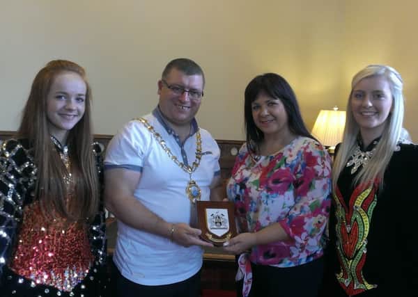 Royal Tara dancers Keira McKay (left) and Rachel Morrow (right) with Royal Tara dance director and teacher Ruth McCalmont-Long, who is receiving a plaque from Mayor of Larne Cllr Martin Wilson.