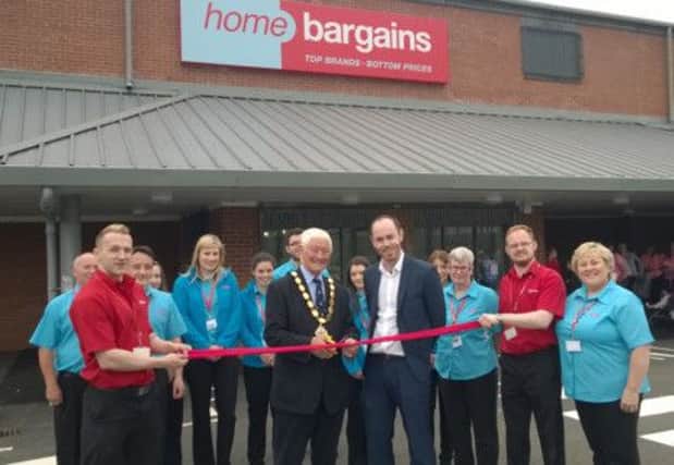 Deputy Mayor Pat McCudden cuts the ribbon to mark the official opening of Home Bargains' new store at Granges Street, Ballyclare. He was joined at the official opening on July 12 by staff and customers.