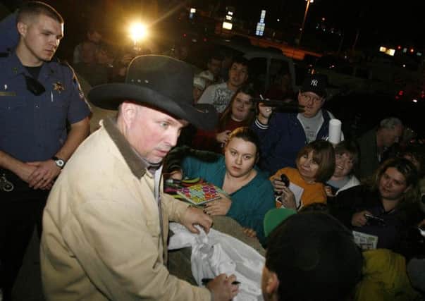 Garth Brooks is greeted by fans outside the Rogers County Courthouse