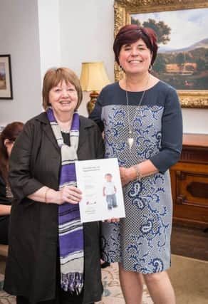 Retired Carrick teacher Joyce Evans receives a certificate in recognition of her volunteering from Barnardos NI director Lynda Wilson. INCT 31-702-CON