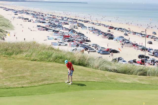 A young golfer putts at Portstewart Golf Club as hunderds of cars decend unto Portstewart Strand Beach on a lovely Wednesday afternoon.PICTURE MARK JAMIESON.