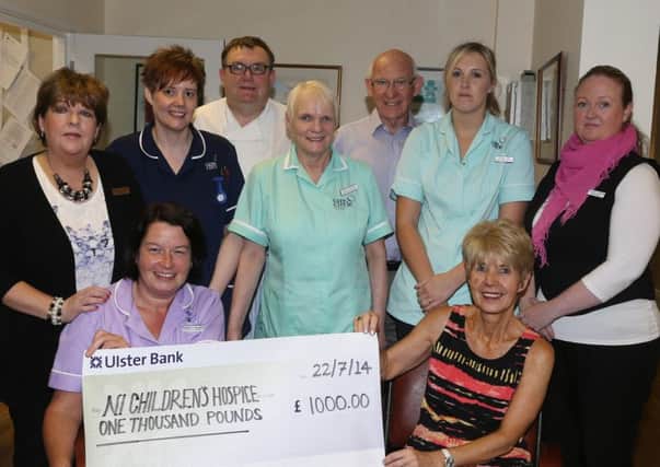 Bernadette McLarnon (front left) presents a cheque for £1000 on behalf of the residents and staff of Slemish Nursing Home to Maureen Baw of the Northern Ireland Children's Hospice while looking on are L-R, Dorothy McKeefry, Melanie Gorman, Ian Denholm,  Moira Thompson, Gerry McCann (Hospice), Jolene Law, Kathryn Dickson. The money was raised from a raffle at the Slemish Nursing Home Fun Day. INBT 31-100JC