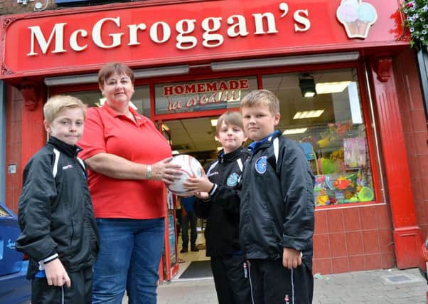 Andrene Millar of McGroggan's shop presents a match ball to Northend United players Owen, Lewis and Jack for the Foyle Cup tournament. INBT 30-809H