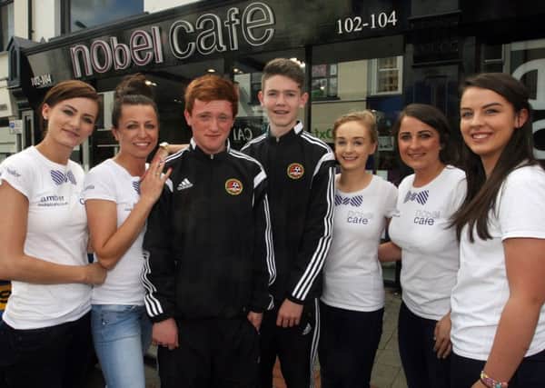 Adam Mairs and Travis McWilliams, members of the Carniny Youth U-16 Foyle Cup team, are pictured with Amber Stewart, Ann Cvat, Aine Cochrane, Laoise McCann and Orla McKillough from the Nobel Cafe who sponsored
 the team. INBT31-200AC