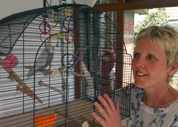 Daphne Dunne and Dusty the budgie at home.