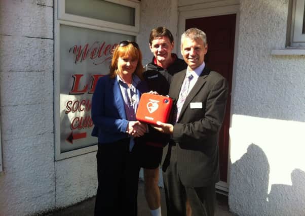 Lyn Kernohan presents Larne FC physio Joe Crawford with a defibillator. Lyn raised the money by running in the Larne Half Marathon relay, and wishes to pass on her warmest thanks to everyone who sponsored her and in particular the family of the late Gary Critchley who donated the proceeds from their annual charity match. Also pictured is Tommy Carmichael from Cardiac Services. INLT 31-642-CON