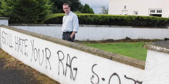 George Duddy, mayor of Coleraine, outside his house on Tuesday morning after the walls were daubed with graffiti overnight