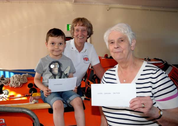 Esther Dorman, Vice Chairperson of Larne RNLI Fundraisers presents prizes to Mrs Doherty and Ethan Campbell which they won in the annual Duck Derby, Mrs Doherty received a voucher from Inver Nurseries and ethan a voucher from Woodsides, Larne  INLT 30-206-AM