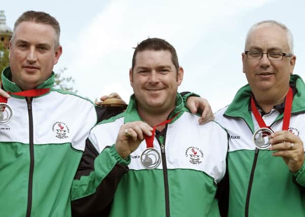 Neil Muholland (centre), with triples team-mates Neil Booth and Paul Daly proudly showing off their silver medals. Pic: Danny Lawson/PA Wire.