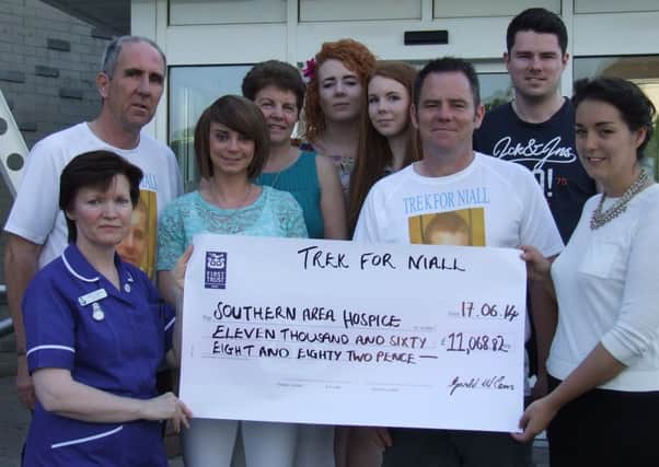 Gerald and Terence present a cheque to Southern Area Hospice accompanied by family members.