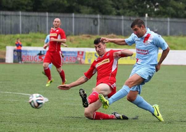 Ballymena United striker Matthew Tipton gets his shot away despite the attentions of Cliftonville defender Johnny Flynn during today's Northern Ireland Hospice Charity Shield match at Solitude. Picture: Press Eye.