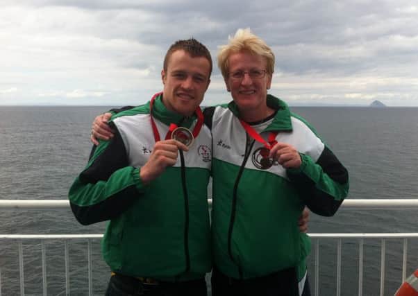 Boxer Steven Donnelly and bowler Barbara Cameron pictured with their Commonwealth Games bronze medals during their journey home from Scotland on Monday.