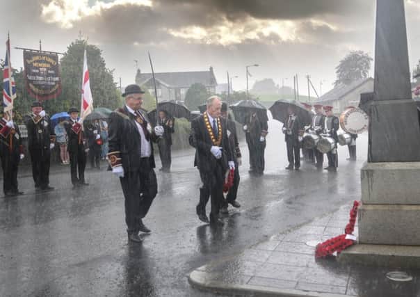 Torrential rain fell as Millar Farr stepped forward to lay a wreath at the Cenotaph in Newmills at the Church parade in the village last Sunday at the start of a week long of activities marking the 100th anniversary of World War 1.