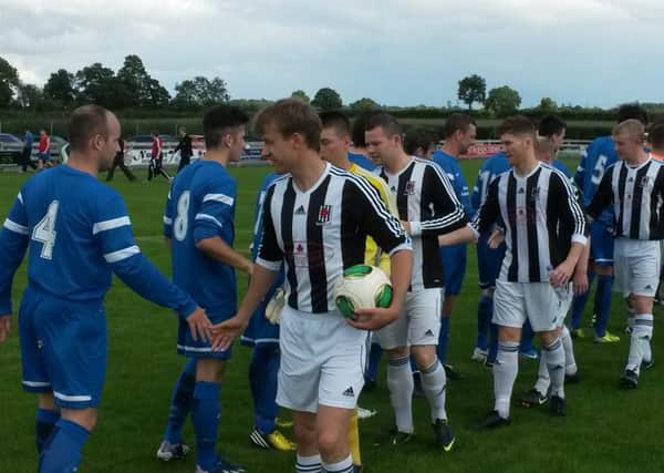 Wakehurst captain Dougie Stevenson leads his team on the pre-match handshake ahead of Saturday's game at Dollingstown.